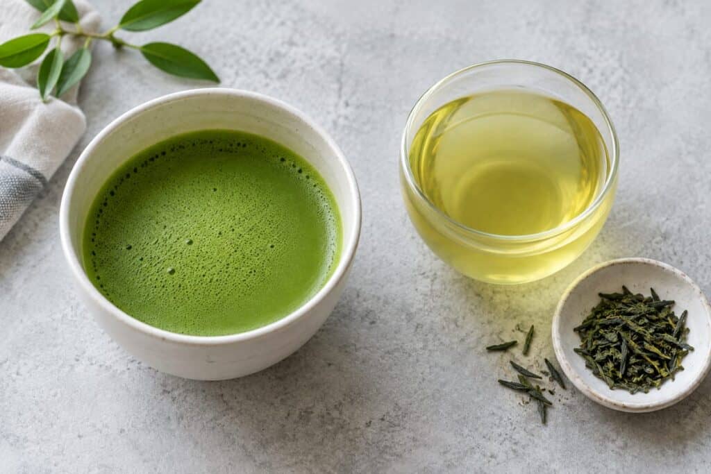 Matcha vs Green Tea: Processing, Taste and How to Choose 4 ماتشا مخفوقة معتمة بجانب شاي أخضر منقوع شفاف