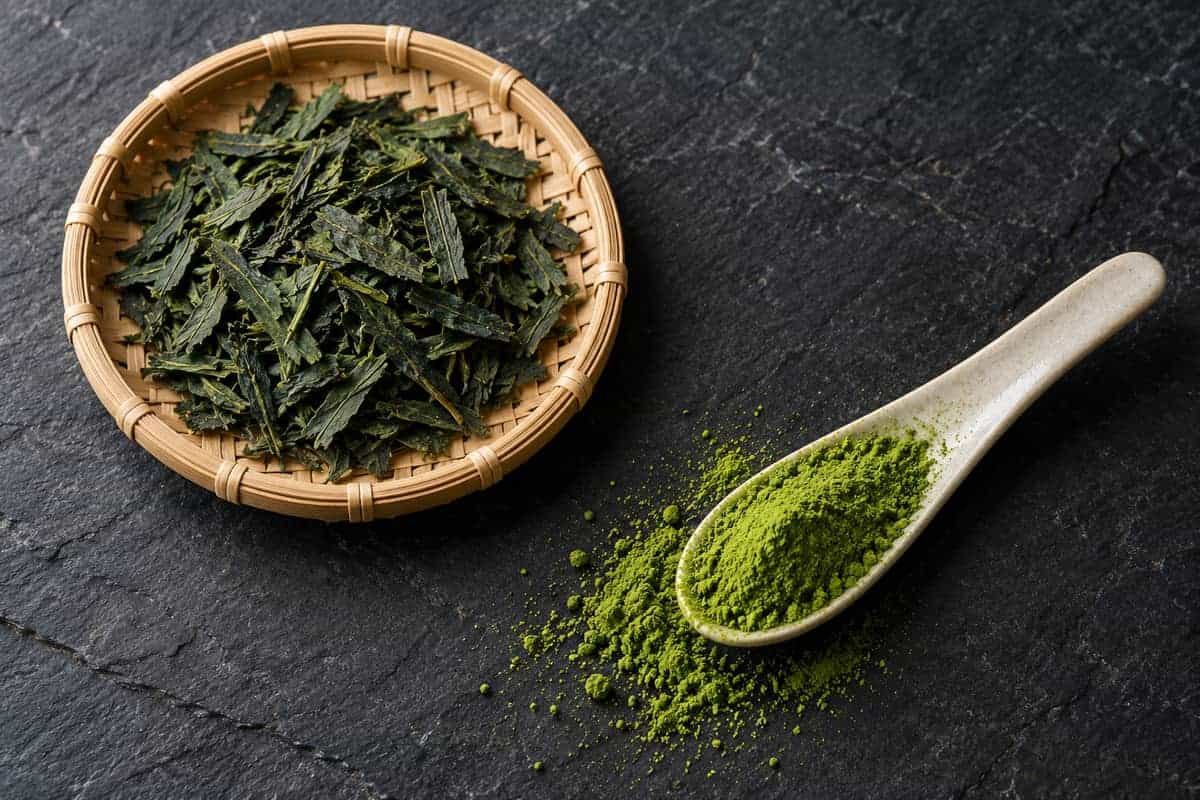 Blue, Pink and Purple “Matcha”: What Is in the Powder? 2 Dry tea-leaf flakes and fine green matcha powder on separate utensils